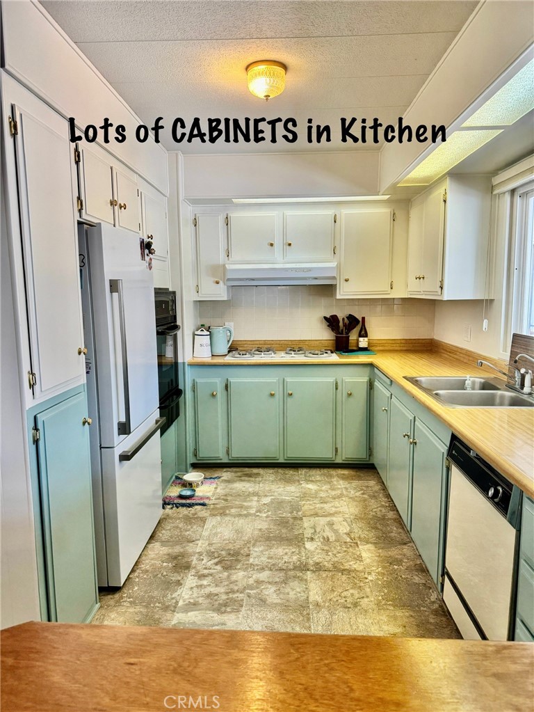 4650 Dulin Road, Unit 11 Fallbrook, CA 92003 - Photo 15 of 38 a kitchen with stainless steel appliances white cabinets a sink and a refrigerator