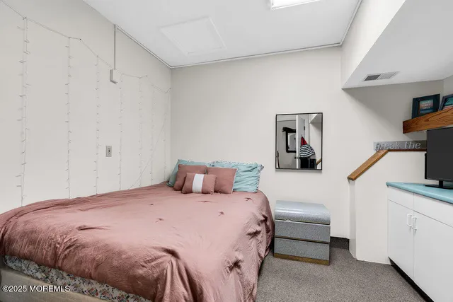 a bedroom with a bed a flat tv screen and a closet