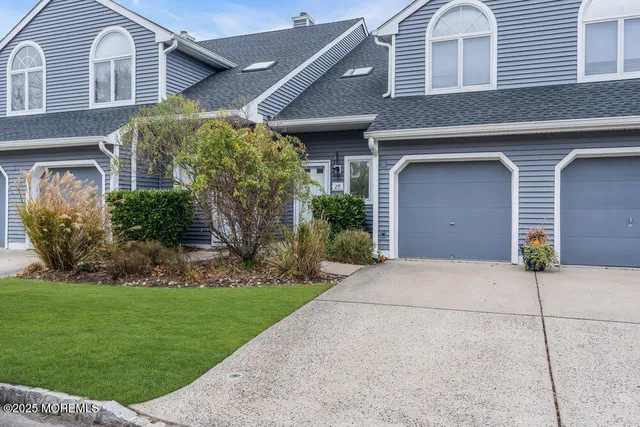 a front view of a house with a garden and plants