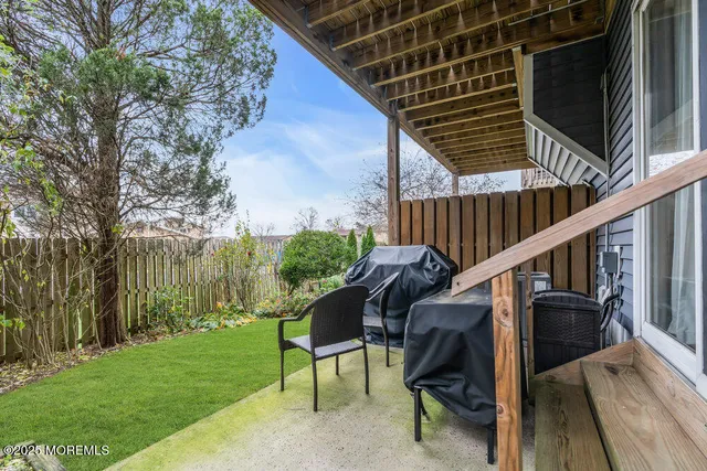 a view of backyard with a table and chairs and a large tree
