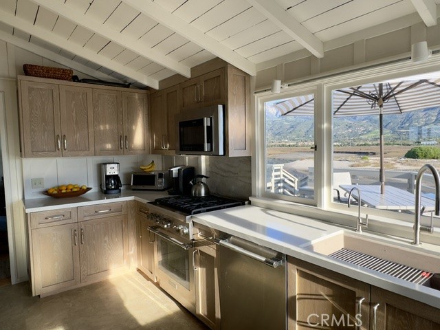 539 Sand Point Road Carpinteria, CA 93013 - Photo 14 of 26 a kitchen with stainless steel appliances granite countertop a sink a stove and a wooden cabinets