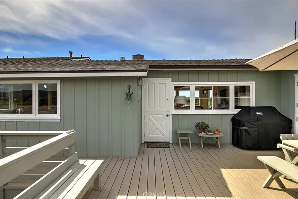 a view of a house with a barbeque and wooden floor