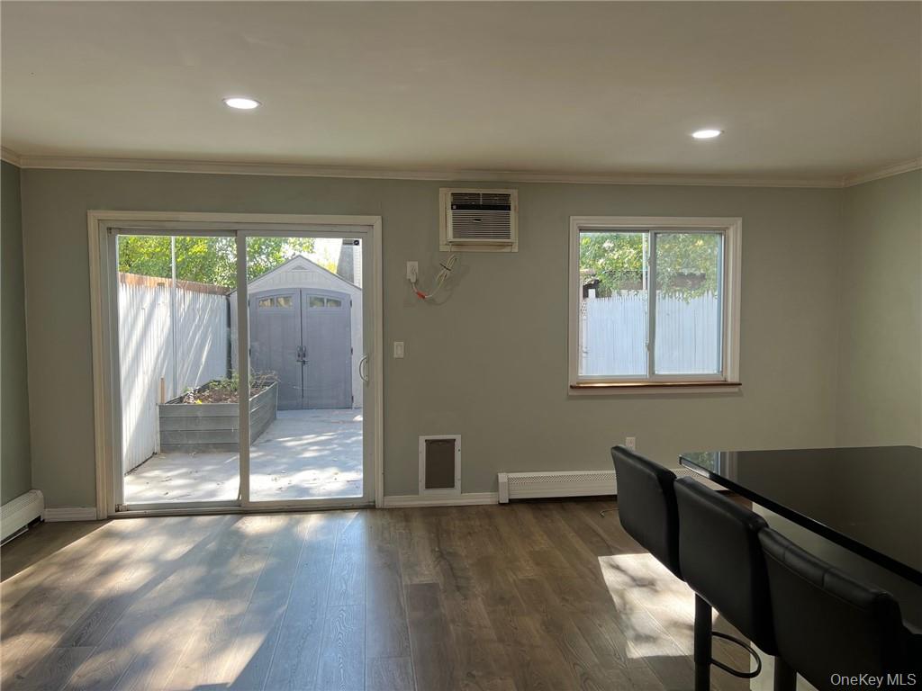 708 Silver Lake-Scotchtown Road Middletown, NY 10941 - Photo 6 of 25 Doorway to outside featuring baseboard heating, crown molding, dark wood-type flooring, and a wealth of natural light