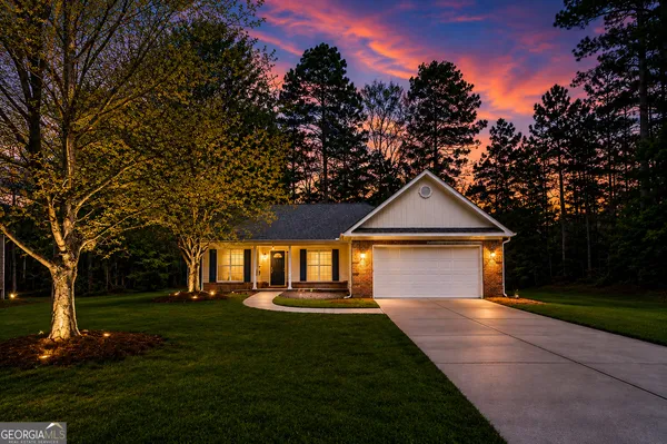 a front view of a house with a yard and trees