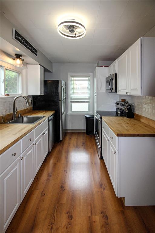 684 Elizabeth Street Bridgeville, PA 15017 - Photo 12 of 34 a large kitchen with stainless steel appliances granite countertop a sink dishwasher stove and oven with wooden floor
