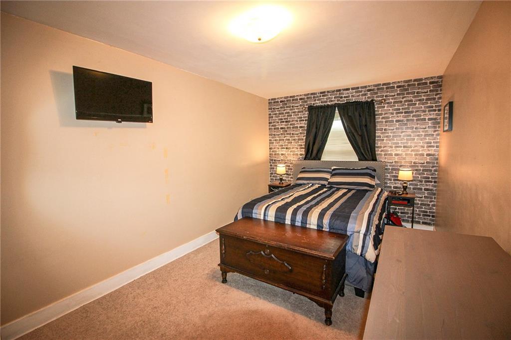 684 Elizabeth Street Bridgeville, PA 15017 - Photo 19 of 34 a bedroom with a bed and a flat screen tv