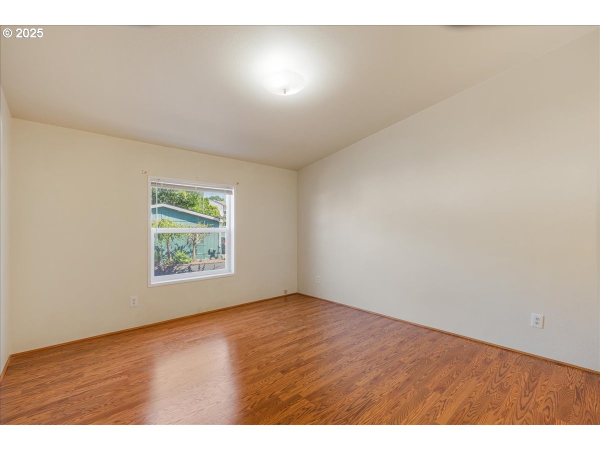 1819 Southeast Orient Drive, Unit 1 Gresham, OR 97080 - Photo 14 of 31 an empty room with wooden floor and windows