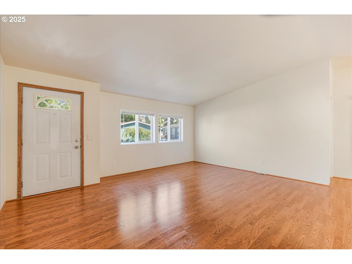 1819 Southeast Orient Drive, Unit 1 Gresham, OR 97080 - Photo 4 of 31 a view of an empty room with wooden floor and a window