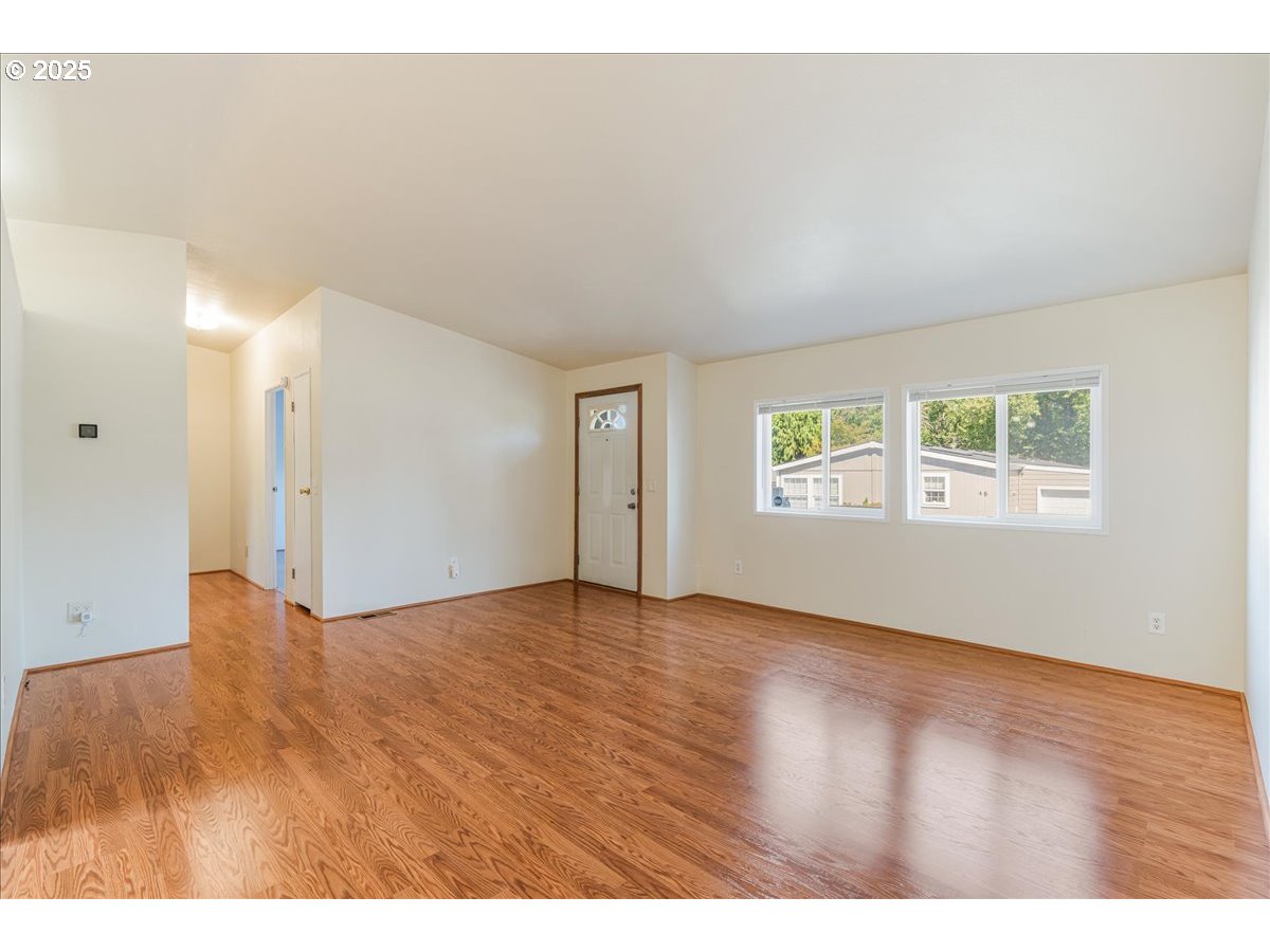 1819 Southeast Orient Drive, Unit 1 Gresham, OR 97080 - Photo 5 of 31 a view of an empty room with wooden floor and a window