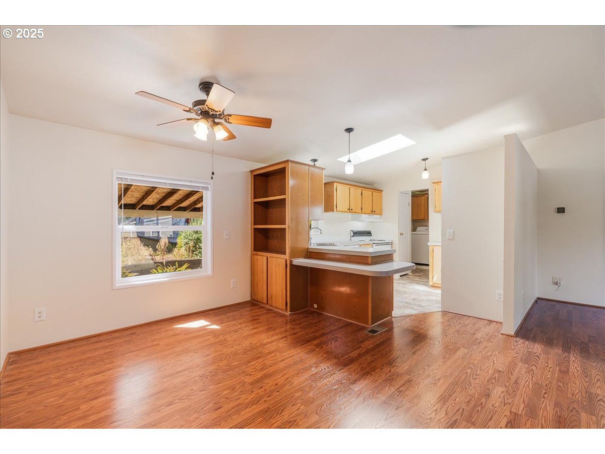 1819 Southeast Orient Drive, Unit 1 Gresham, OR 97080 - Photo 8 of 31 a open kitchen with stainless steel appliances granite countertop a sink a stove a refrigerator cabinets and wooden floor