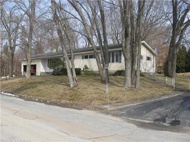 a view of a house with a yard and large tree