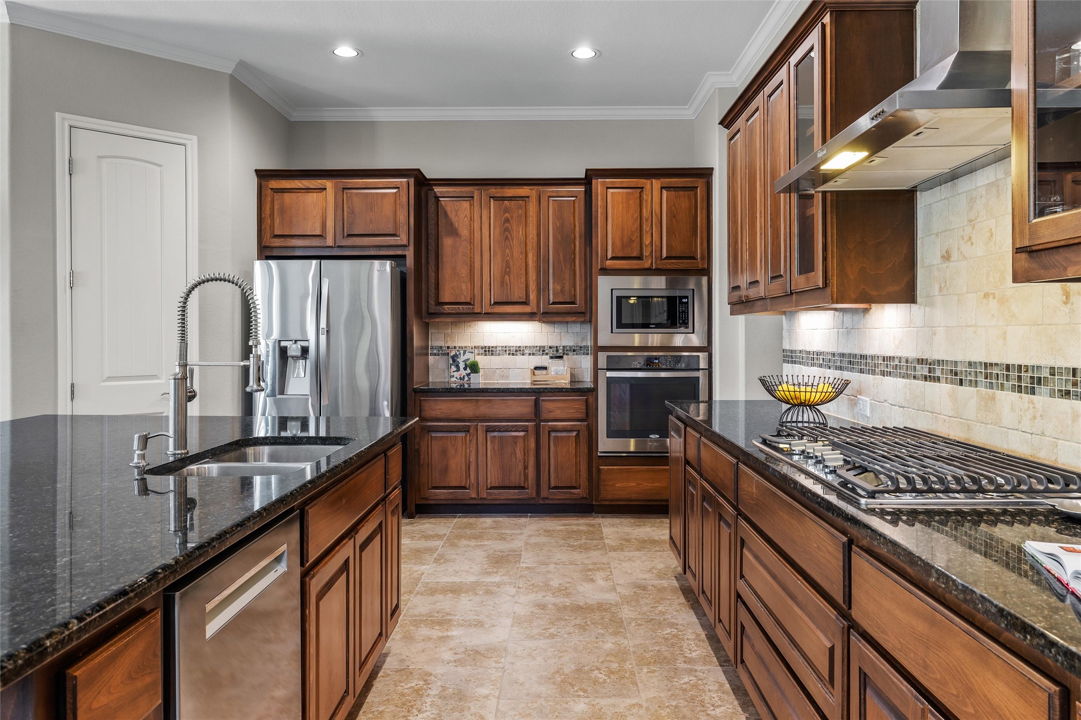 151 Swallowtail Drive Austin, TX 78737 - Photo 11 of 40 a kitchen with stainless steel appliances granite countertop a stove top oven a sink dishwasher a refrigerator and cabinets with wooden floor