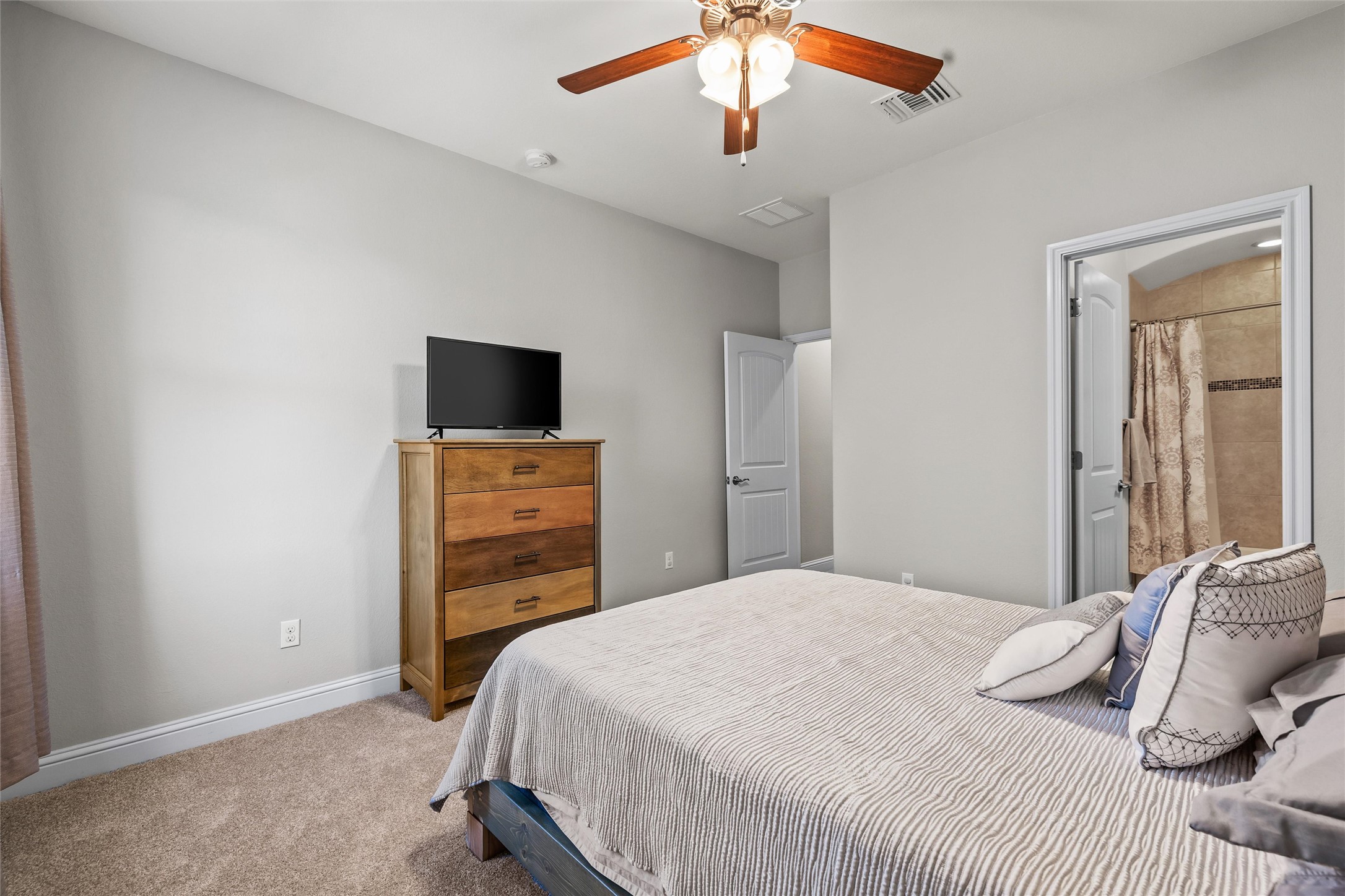 151 Swallowtail Drive Austin, TX 78737 - Photo 25 of 40 a bedroom with a bed and a flat tv screen on a dresser