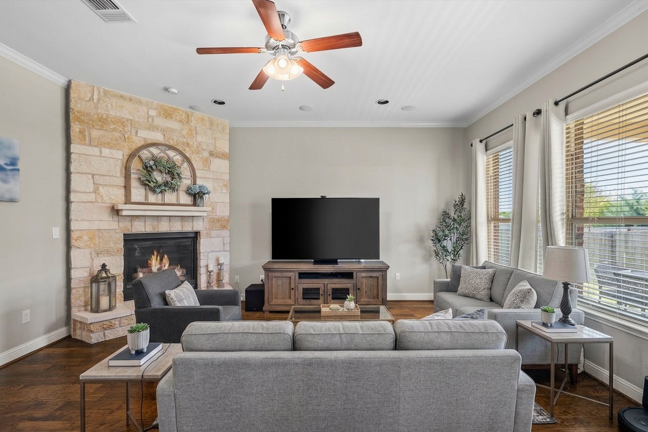 151 Swallowtail Drive Austin, TX 78737 - Photo 6 of 40 a living room with furniture a fireplace and a flat screen tv