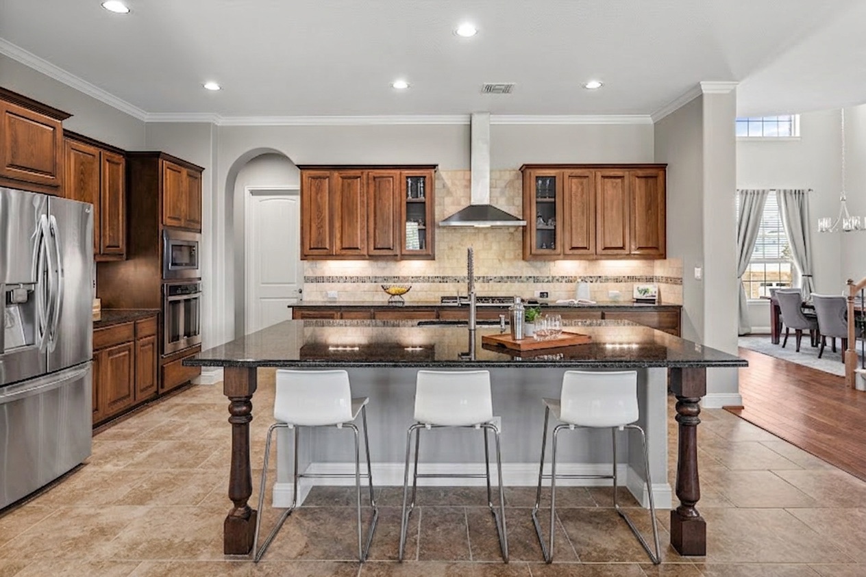 151 Swallowtail Drive Austin, TX 78737 - Photo 10 of 40 a kitchen with stainless steel appliances granite countertop a table chairs refrigerator and microwave