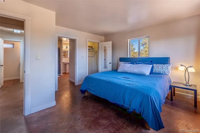 a bedroom with a bed and a dresser next to a window