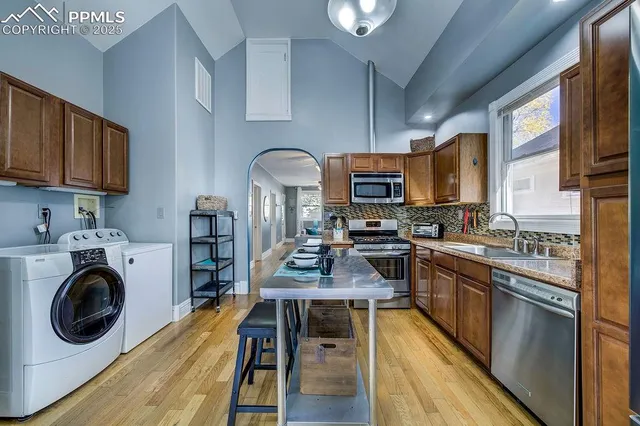 a kitchen with wooden cabinets stainless steel appliances and sink