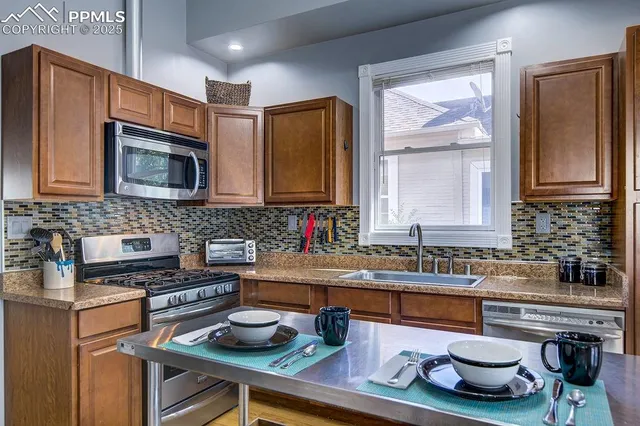 a kitchen with kitchen island granite countertop a sink and wooden cabinets