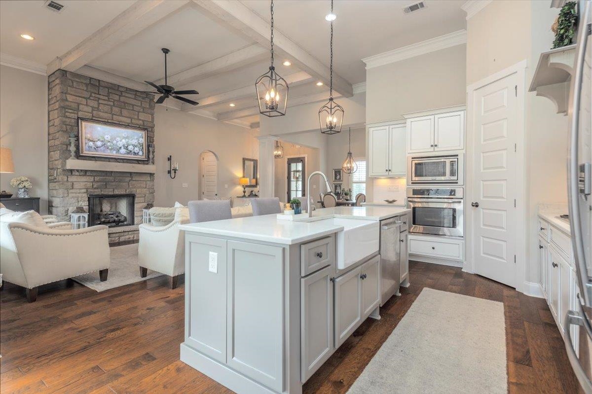 608 Cypress Run Cove Collierville, TN 38017 - Photo 40 of 40 Kitchen featuring open floor plan, ceiling fan, a center island with sink, dark wood-style flooring, and beam ceiling