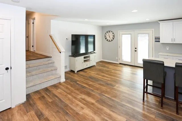 a view of a livingroom with wooden floor and furniture