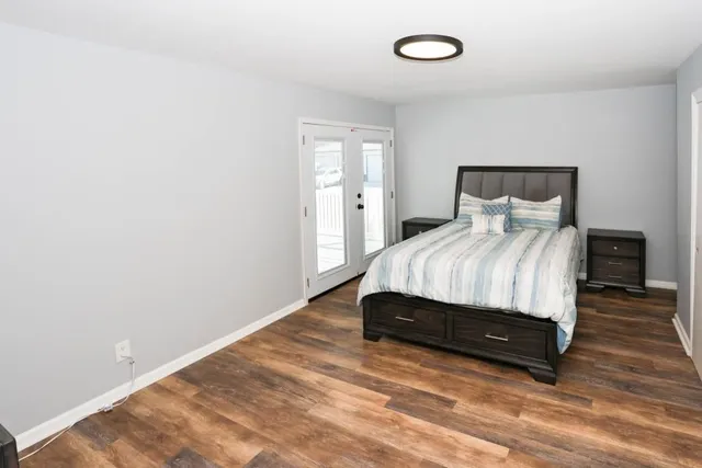 a spacious bedroom with a bed and a night stand