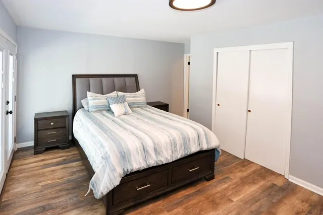 a spacious bedroom with a bed and a wooden floor