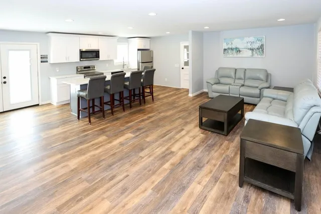 a living room with furniture and a wooden floor