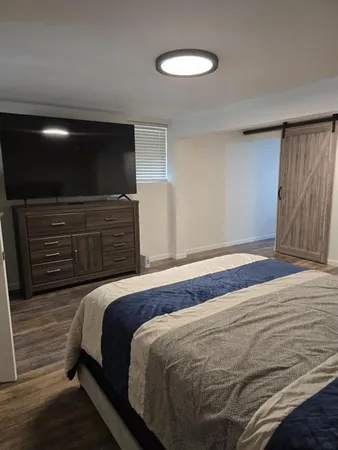 a bedroom with a bed and wooden floor