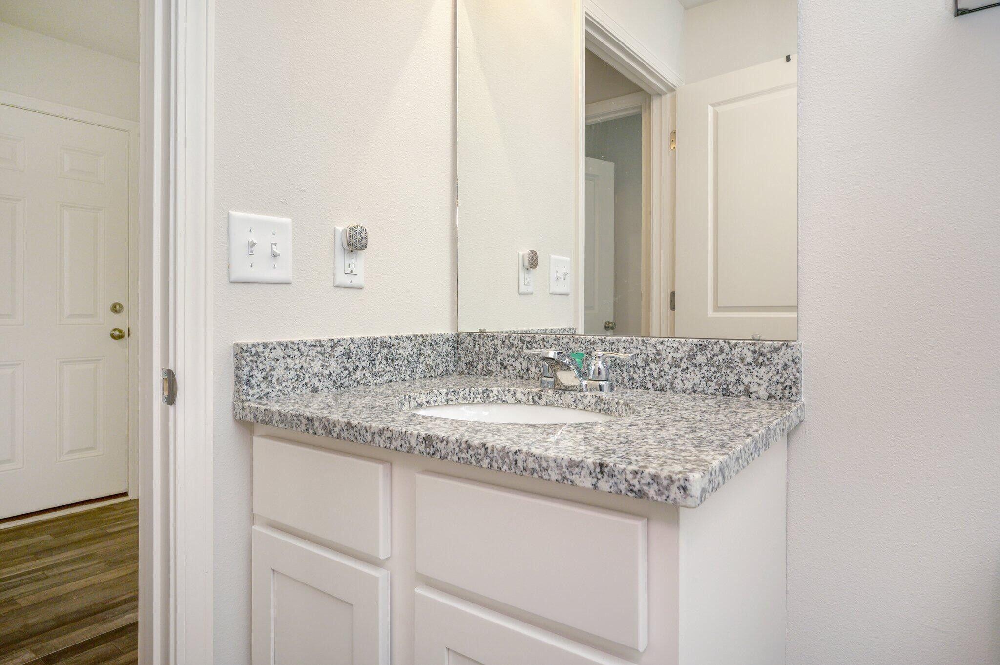 42 Lockwood Way East DeFuniak Springs, FL 32435 - Photo 25 of 38 a bathroom with a granite countertop sink and a mirror