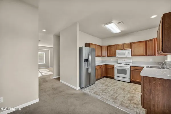 a kitchen with refrigerator cabinets and wooden floor