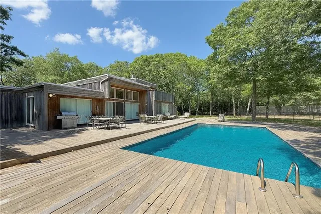 a space with wooden floor and trees in the background