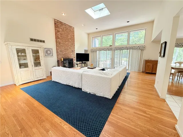 a living room with a bed wooden floor and a table