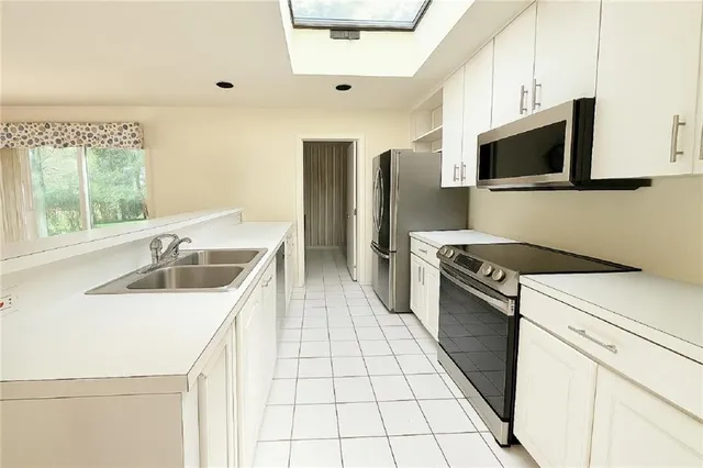 a kitchen with stainless steel appliances a sink a stove and a refrigerator
