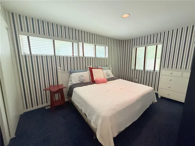 a bedroom with a large bed and a window