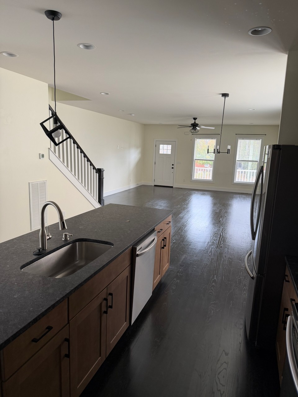 a kitchen with stainless steel appliances granite countertop a sink a stove and a wooden floor