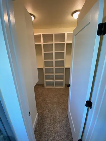 a view of hallway with a large window and wooden floor
