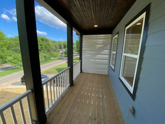 a view of hallway with a large window and wooden floor