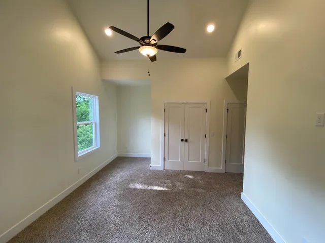 an empty room with a window and a fan