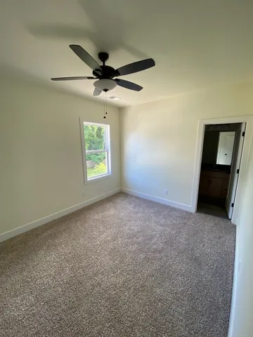 an empty room with windows and ceiling fan