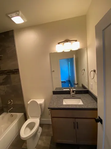 a bathroom with a sink mirror vanity and toilet