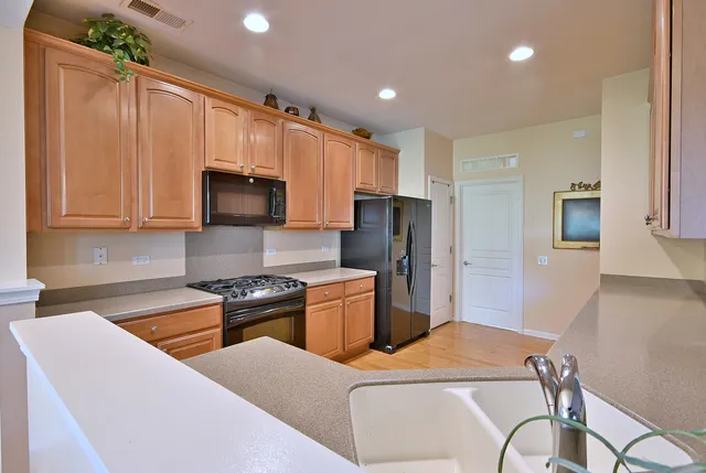 a kitchen with stainless steel appliances granite countertop a stove a sink and a microwave