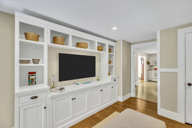 a living room with flat screen tv and dresser
