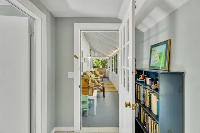 a view of a hallway with wooden floor and a living room