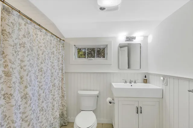 a bathroom with a sink mirror and toilet