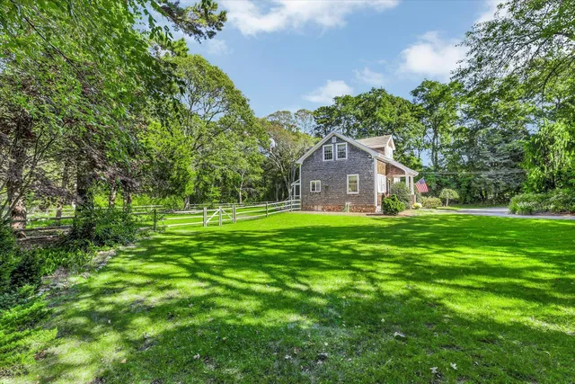 a front view of a house with a yard and trees