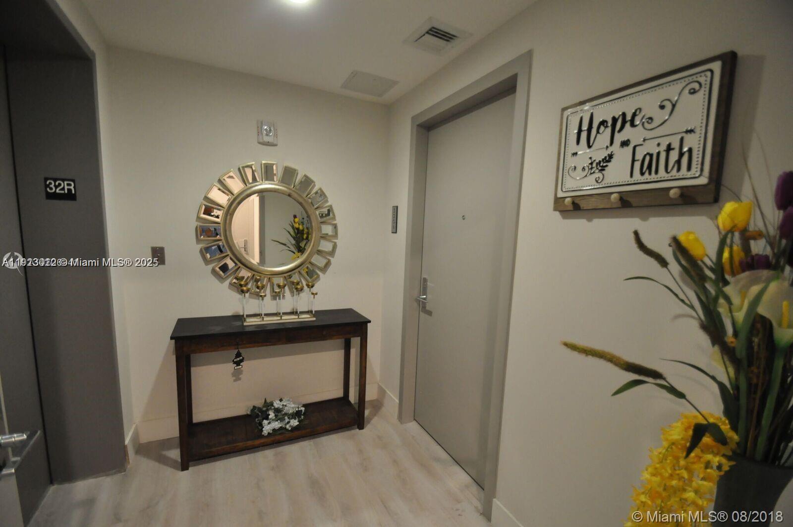 488 Northeast 18th Street, Unit 3208 Miami, FL 33132 - Photo 13 of 17 a view of a hallway with paintings on the wall