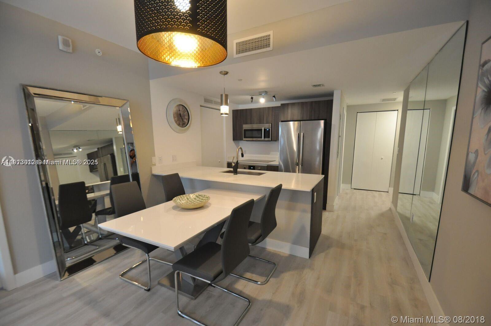 488 Northeast 18th Street, Unit 3208 Miami, FL 33132 - Photo 5 of 17 a kitchen with a table and chairs in it