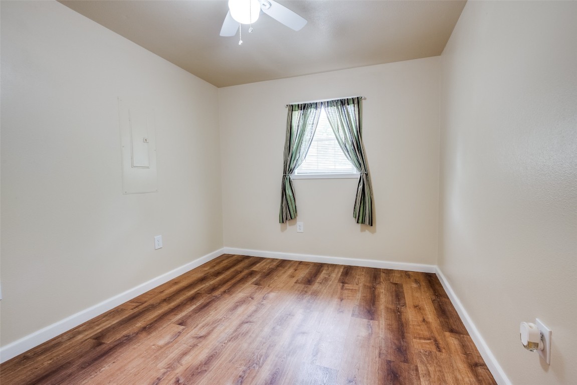 1200 West Phillips Street Alvin, TX 77511 - Photo 16 of 31 an empty room with wooden floor and windows