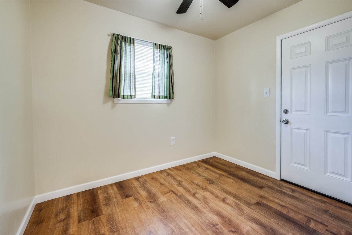 1200 West Phillips Street Alvin, TX 77511 - Photo 19 of 31 a view of empty room with wooden floor and fan