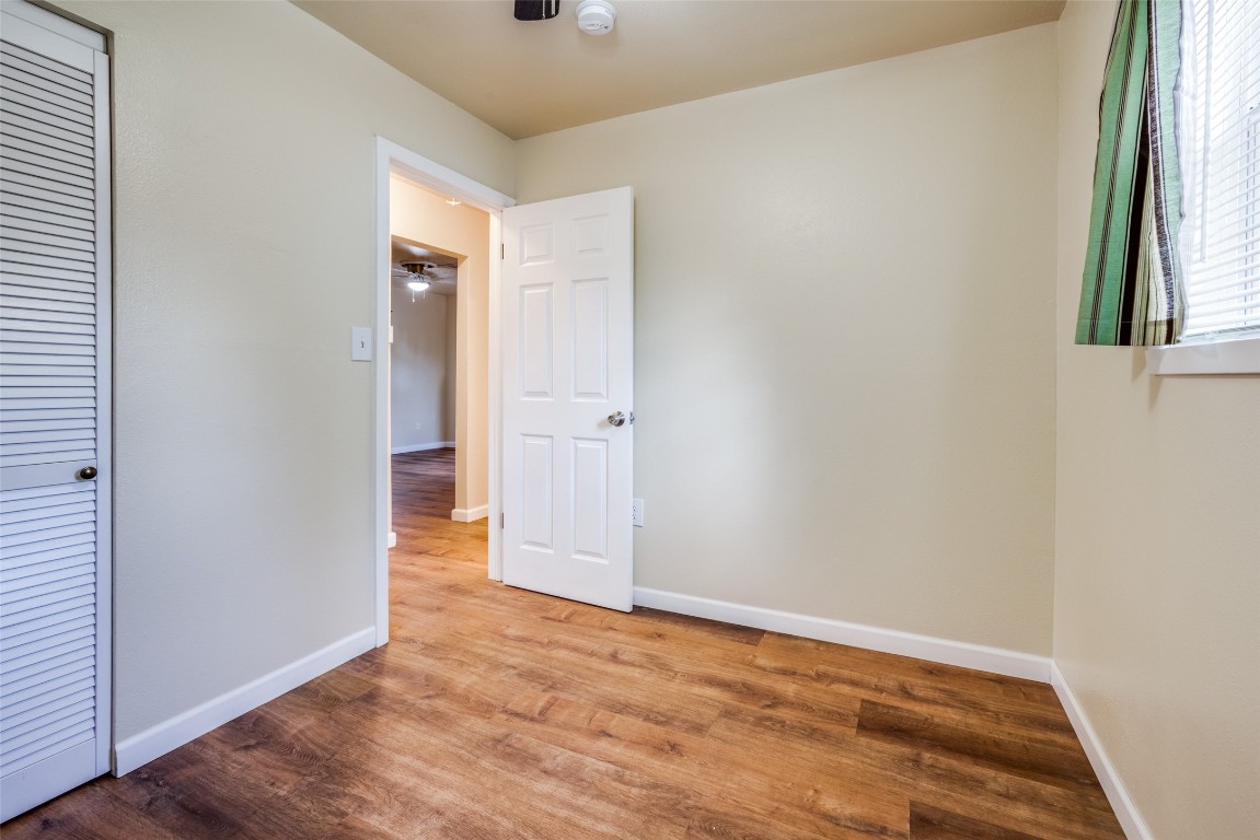 1200 West Phillips Street Alvin, TX 77511 - Photo 20 of 31 an empty room with wooden floor and windows